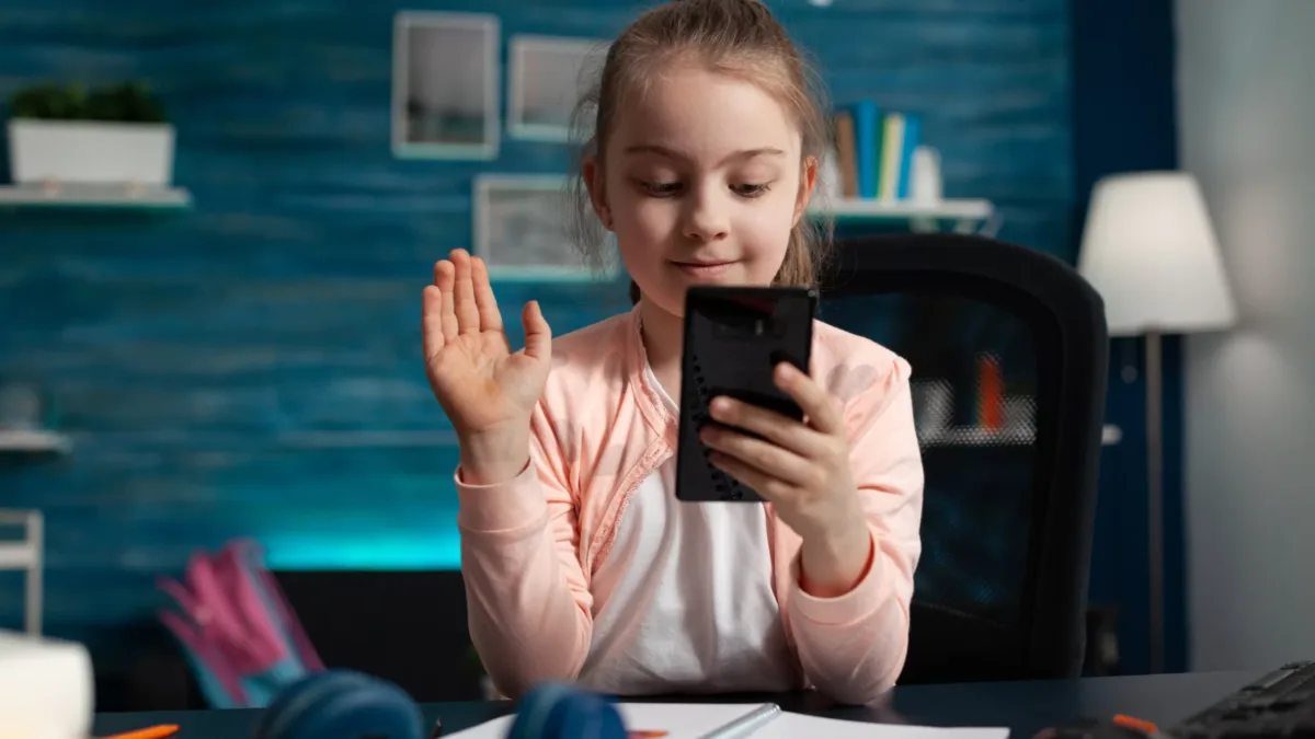 Little child greeting remote friend during online videocall meeting conference